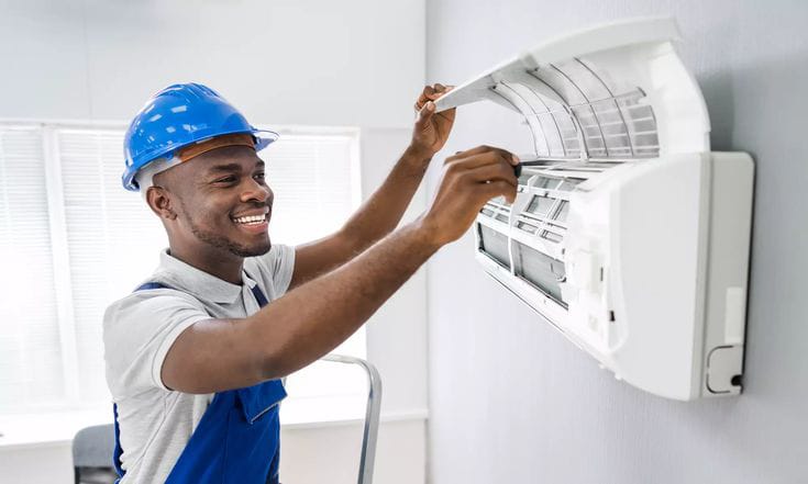 Technician servicing a wall-mounted split air-conditioning unit
